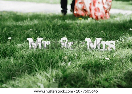 Mr and Mrs White Wedding letters on green grass and grooms on background. Wedding decor. Wedding details