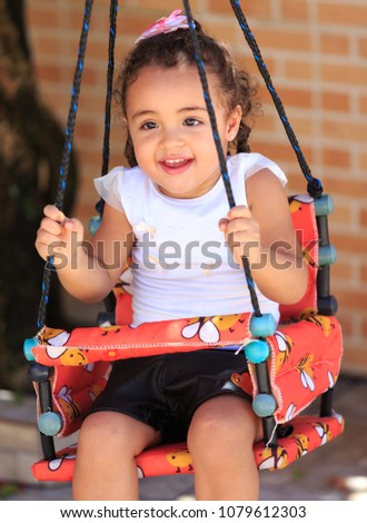 Portrait of a little girl on a swing