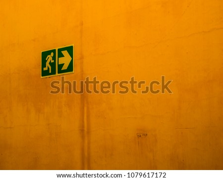 Pedestrian sign on a yellow wall