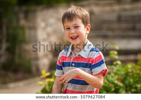 Cute Caucasian kid playing with water fountain in the public park. Happy life, happy childhood stock image. Healthy child concept. Pre-school age boy. Back to school idea. Summer vacation.