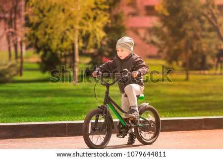 Happy four years old boy learning how to ride a bike. First riding lessons