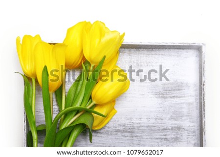 Yellow tulips in an old wooden box. The view from the top