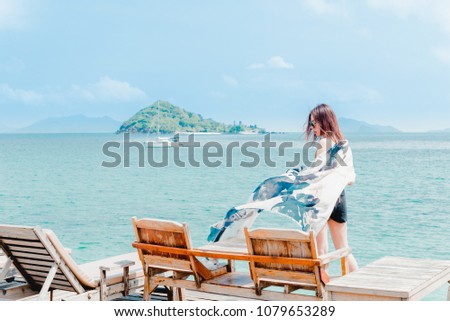 Outdoor summer portrait of young pretty woman looking to the ocean and relaxing with blue sky,Happiness Holiday Concept.