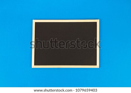 Empty chalkboard on blue background with copy space.