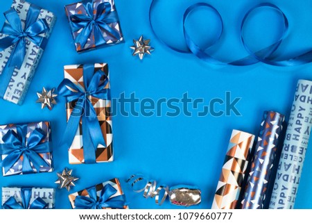Gift boxes composition on blue background. Flat lay text space.