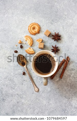 Glass of Black Coffee , Star Anise, Brown sugar and Cookies on grey stone background. Top view