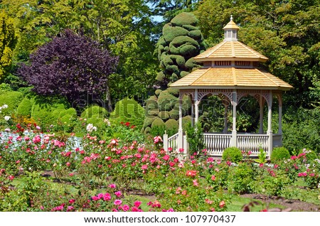 Wooden gazebo in colorful spring garden
