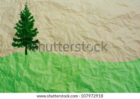 tree and green field on recycled paper