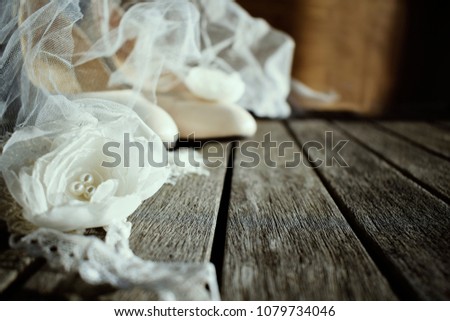 Wedding shoes on a wooden background. Wedding veil, decorative chiffon flowers, white lace
