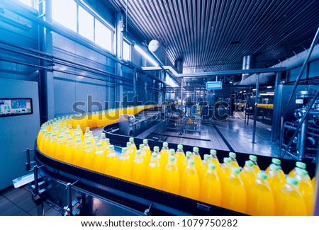 Beverage factory interior. Conveyor with bottles for juice or water. Modern equipments Royalty-Free Stock Photo #1079750282
