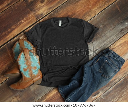 Mockup of blank gray tshirt on rustic wood background with cowboy boots and jeans