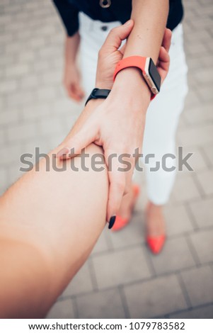 Female touching her smar twatch with red strap