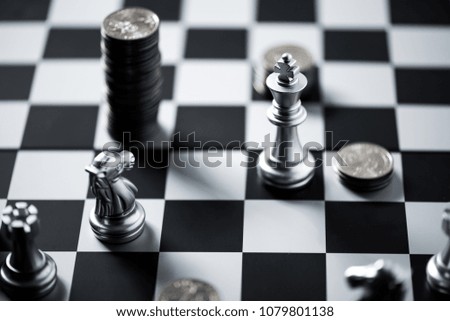 chess pieces and stack of coins on a chessboard, business strategy concept