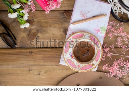 Black fragrant coffee, flowers and glasses. Good morning, bright sunny colors. Women's accessories and notepad with a pen. Planning. Cozy atmosphere
