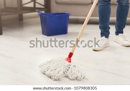 Unrecognizable woman with cleaning equipment ready to clean house. Cropped girl holding mop, professional cleaning service concept, copy space