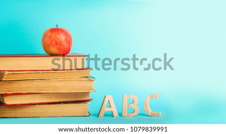 the concept of education. apple, books and alphabe, blue background, place for text, back to school, copy space
