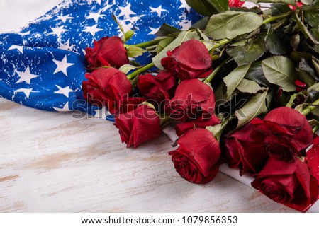 Fresh red roses on wood desk with american flag. Memorial day