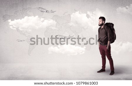 Handsome young man standing with a backpack on his back and planes in front of a world map as a background 