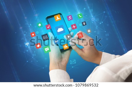 Female hand using smartphone with colorful application icons around