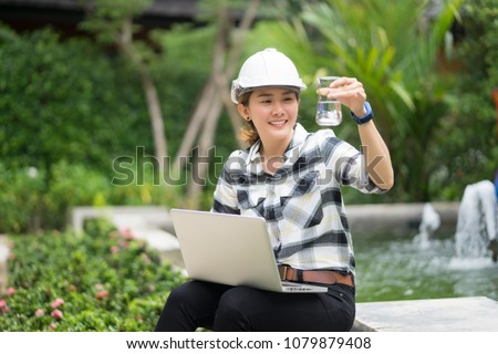 World environment day concept ,Thai Asian Female engineering working with a tablet laptop at sewage treatment plant, engineer controlling the quality of water , aerated activated sludge tank  Royalty-Free Stock Photo #1079879408