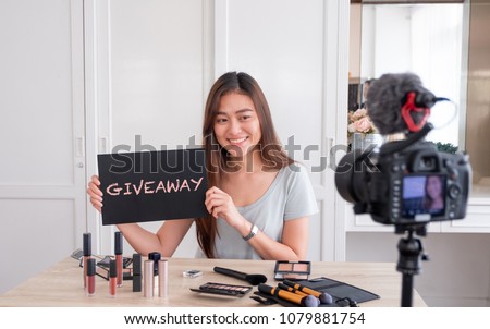 Asian young female blogger giveaway gift to fan following channel while recording vlog video with makeup cosmetic at home online influencer on social media concept.live streaming viral Royalty-Free Stock Photo #1079881754