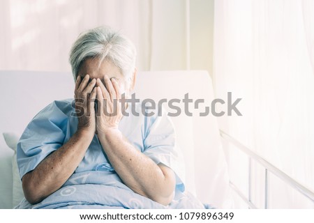 Elderly patient alone in bed. Alone and stress, missing her grand children. Hands on face pose. Very senior, old chinese woman. Royalty-Free Stock Photo #1079896349