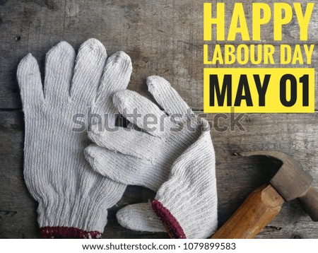 Concept of gloves, hammer  on wooden background with word HAPPY LABOUR DAY MAY 01.