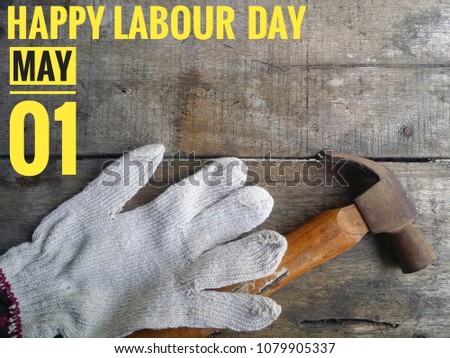 Concept of gloves, hammer on wooden background with word HAPPY LABOUR DAY MAY 01.