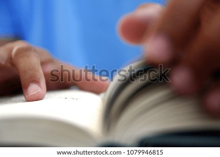 Close up photo of a person's hand while reading a book