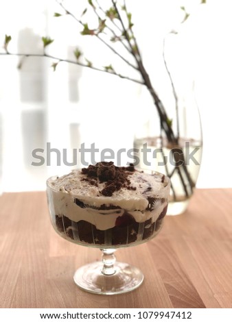 Chocolate trifle in a glass dish. Moody blurred background.wooden table
