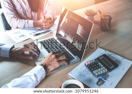 Two colleagues discussing data with  new modern computer laptop on desk table. Close up business team analysis and strategy concept. Royalty-Free Stock Photo #1079951246