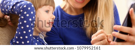 Cute little girl on floor carpet with mom use cellphone calling dad portrait. Life style apps social web network wireless ip telephony concept