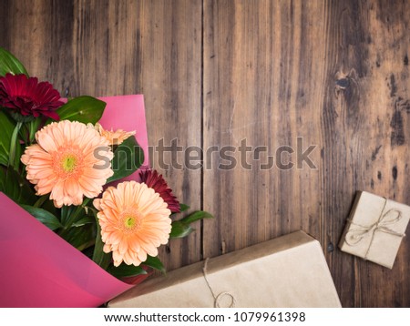 Bouquet of flowers on wood background. Gift boxes tied with ribbon and rope with bows. Top view of Chrysanthemums with decorative plants for birthday card, invitation. Selective, blurred soft focus
