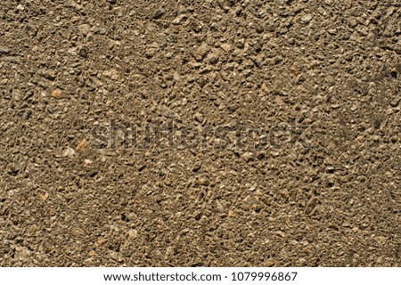 Detail of small brown and grey stones wall texture for background. Ancient wall. Different shape little stones