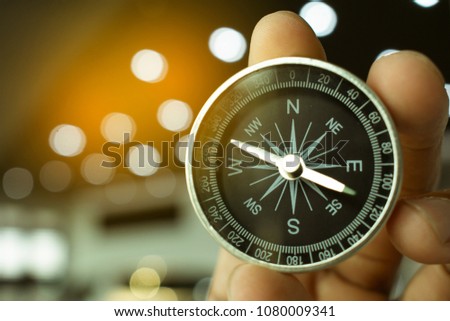 holding compass on blurry background. Using wallpaper or 
background travel or navigator image.