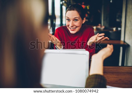 Cheerful young student explaining new successful plan colleague during distance job at laptop device connected to wireless 4G internet.Positive hipster girl telling funny story while gesturing hands