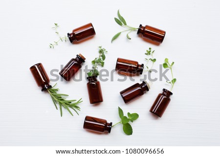 Top view, Bottle of essential oil with herbs  sage, marjoram, rosemary, oregano, mint, thyme and lemon thyme  on white background.