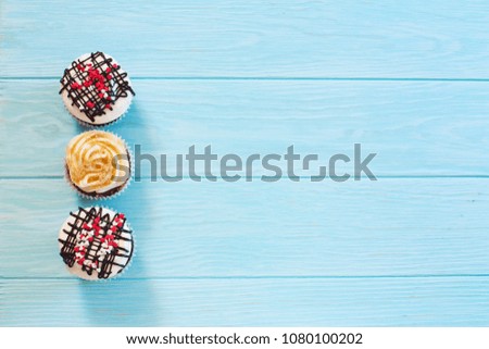 Vanilla and chocolate cupkcake with meringue on blue wood background. Top view. Copy space