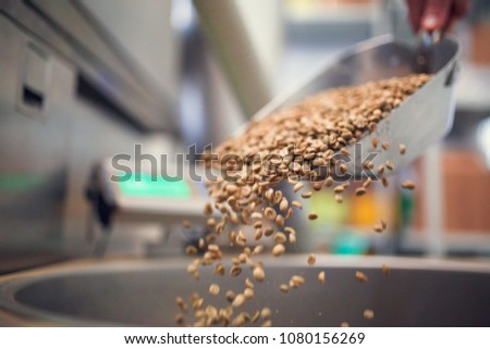 Photo of coffee beans poured from iron scoop
