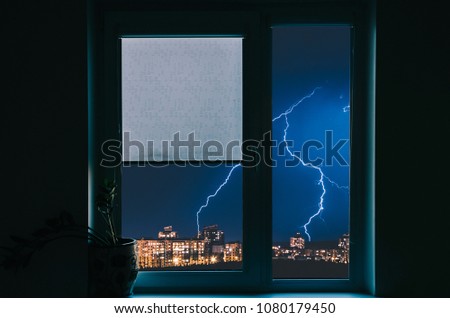 View from window on thunder storm in city
