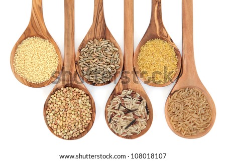 Cereal and grain selection of bulgur wheat, buckwheat, couscous, rye grain and brown and wild rice in olive wood spoons on white background. Royalty-Free Stock Photo #108018107
