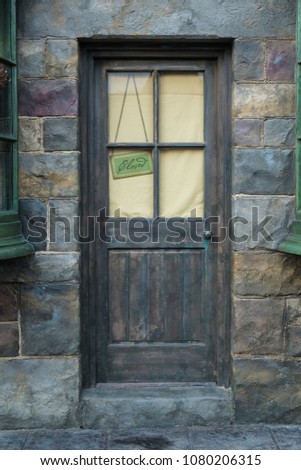 Old wooden door with close sign hang behind the glass window