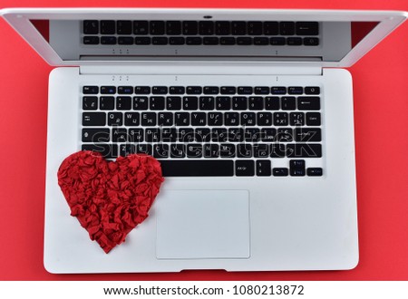 Red hand made heart on the keyboard of notebook