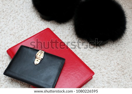 Stylish home fur slippers, a passport in a black leather case and a red leather planner for 2018
