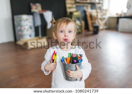 Beautiful young kid with color pencils. Closeup portrait