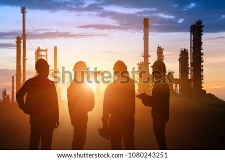 Silhouette of Teams engineer and foreman working at petrochemical oil refinery in sunset Royalty-Free Stock Photo #1080243251