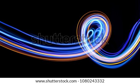 Blue and gold light painting, long exposure photography, abstract swirls and loops against a black background