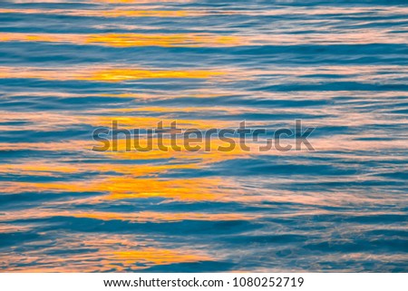 Sunset orange colors reflecting in ocean waves