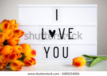 lightbox with text "I love You" and tulip flowers on the table