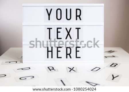 vintage lightbox with words "your text here" and letters on the table